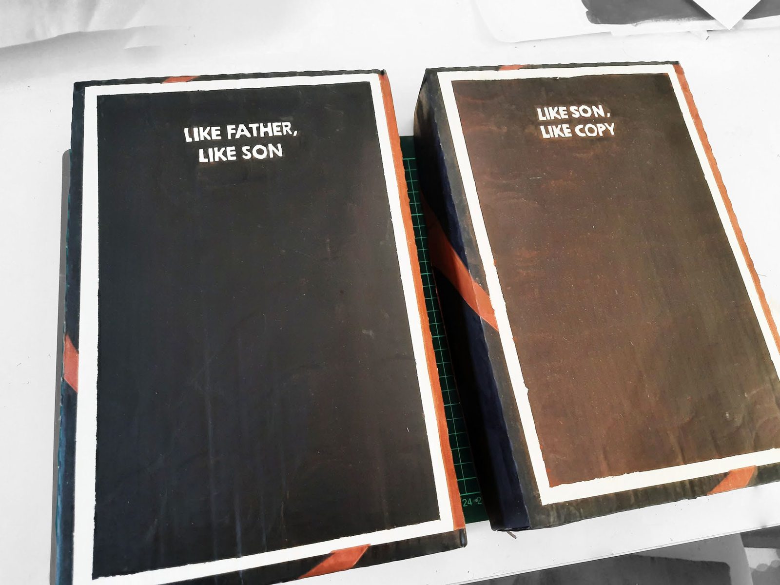 Two black painted cartons side by side